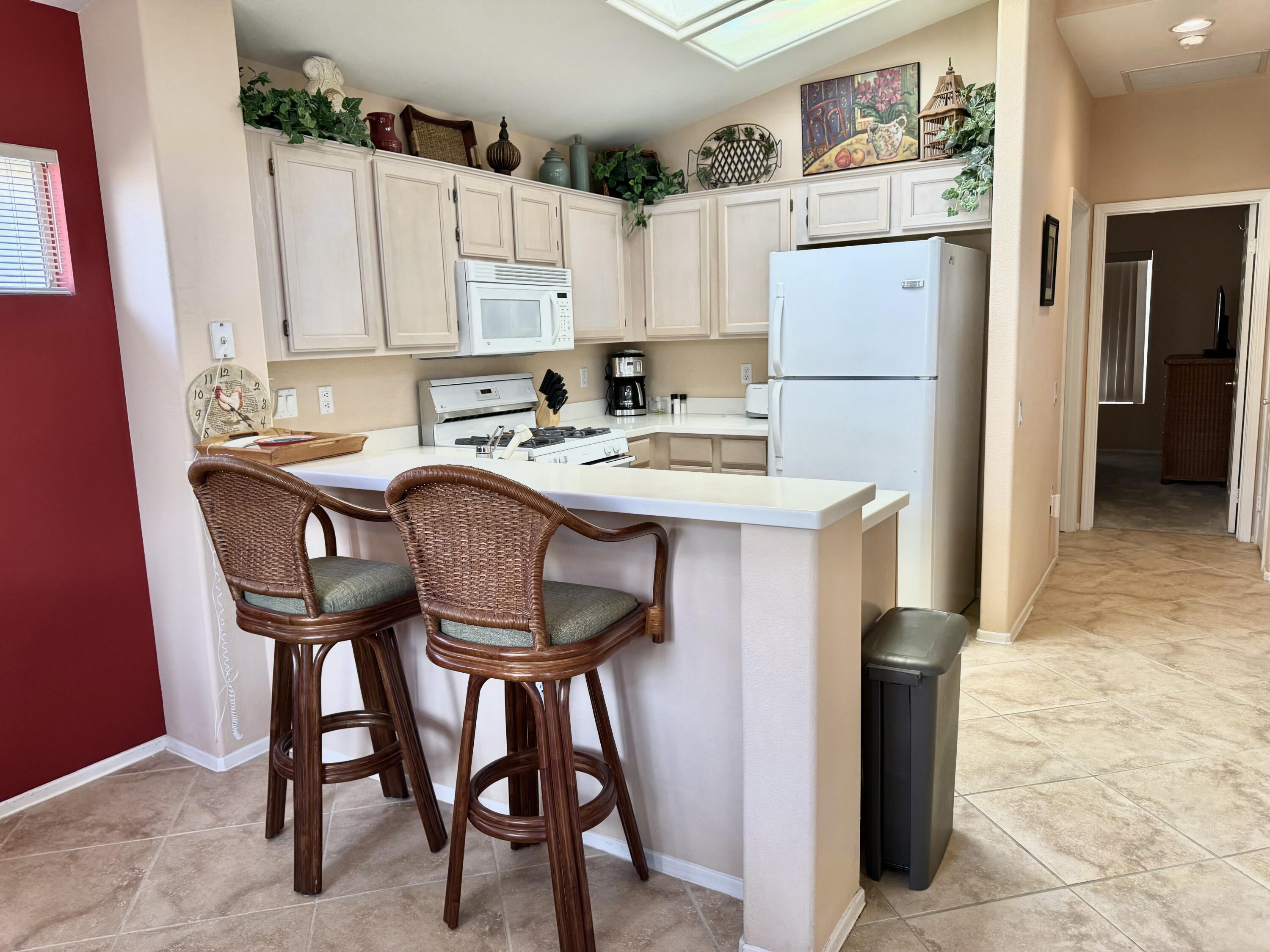 78376 Moongold Road Palm Desert, CA 92211 - Photo 5 of 36 a kitchen with stainless steel appliances a table chairs and a refrigerator