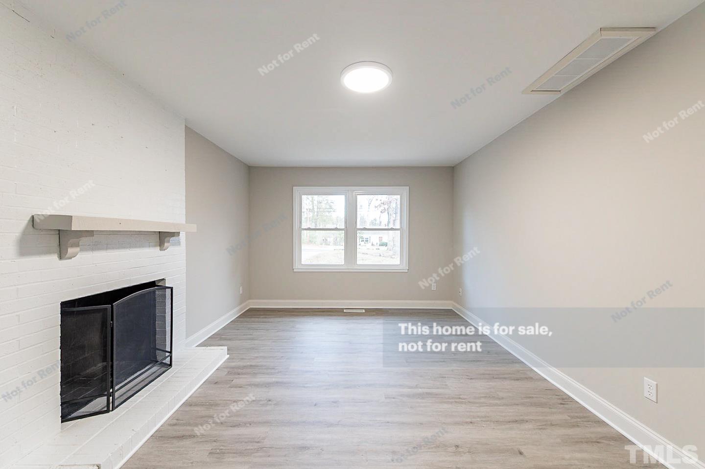1328 Clermont Road Durham, NC 27713 - Photo 5 of 25 a view of empty room with wooden floor and fireplace