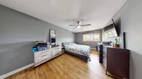 a bedroom with a bed window and a flat screen tv
