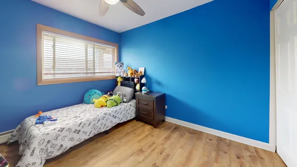 a bedroom with a bed table and a lamp