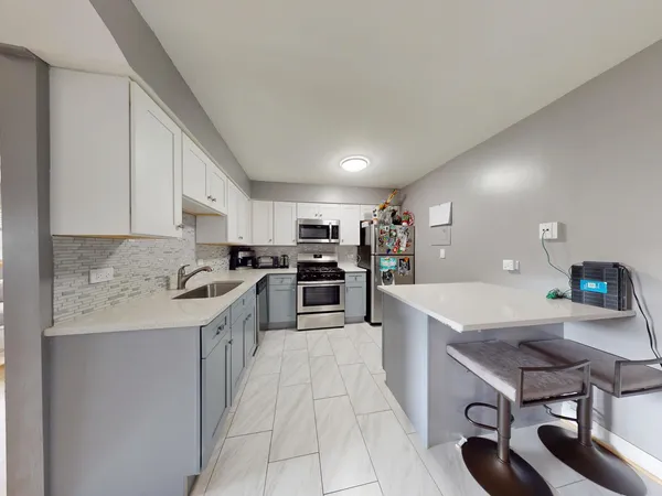 a kitchen with a sink a counter top space stainless steel appliances and cabinets