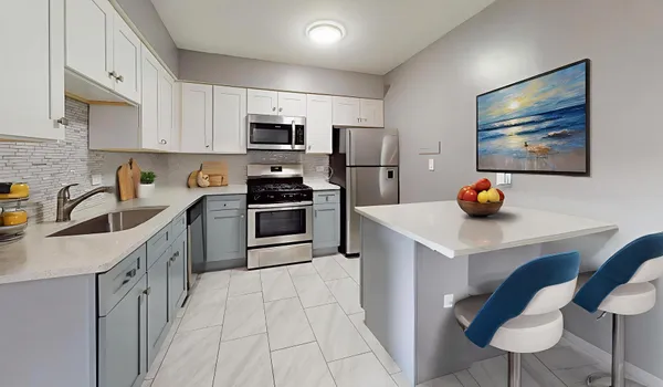 a kitchen with stainless steel appliances granite countertop a sink a stove a refrigerator cabinets a dining table and chairs