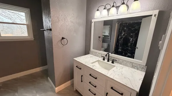 a bathroom with a sink vanity and a mirror