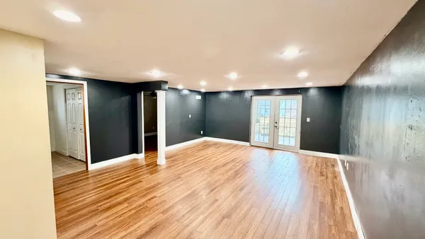 a view of an empty room with wooden floor
