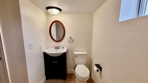 a bathroom with a toilet a sink and a mirror