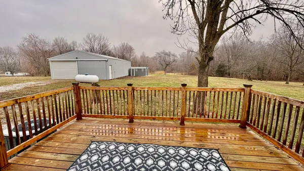 a view of a brick house with wooden fence