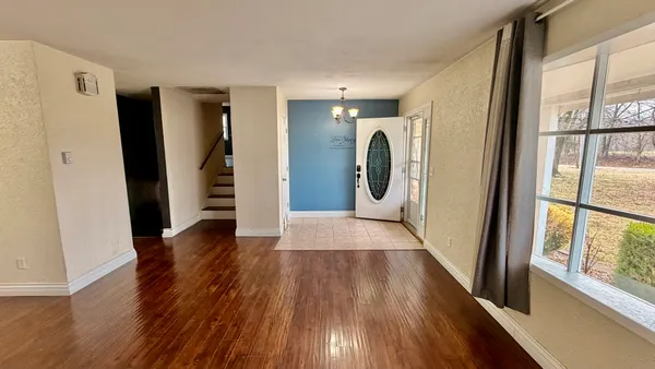 a view of a hallway with wooden floor and door