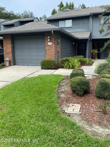 a view of a house with plants and a bench