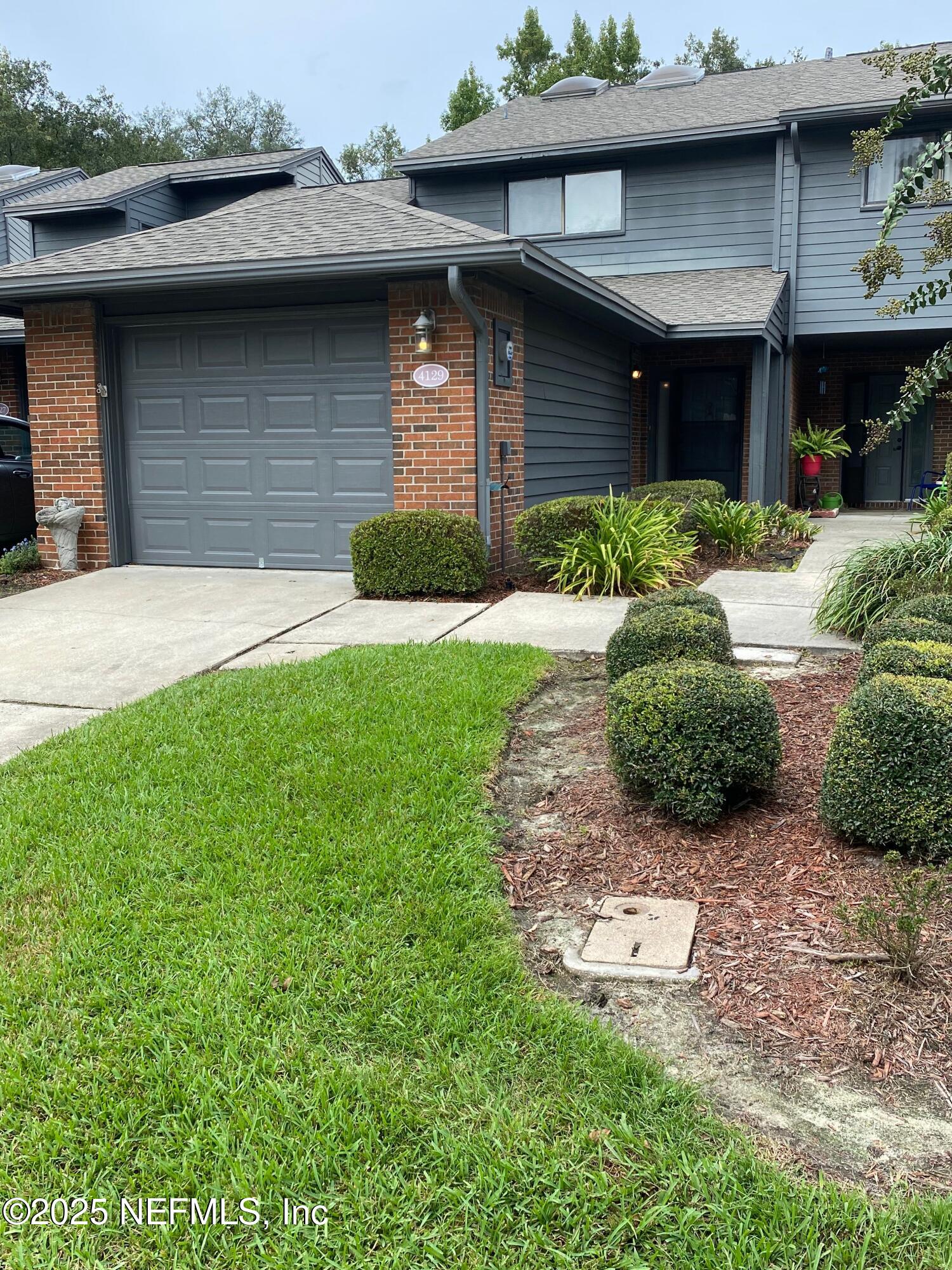 4129 Quiet Creek Loop Middleburg, FL 32068 - Photo 1 of 24 a brick house with a small garden area