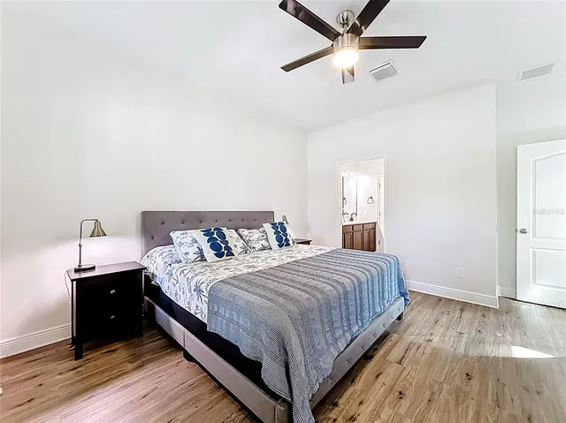 a bedroom with a bed and wooden floor
