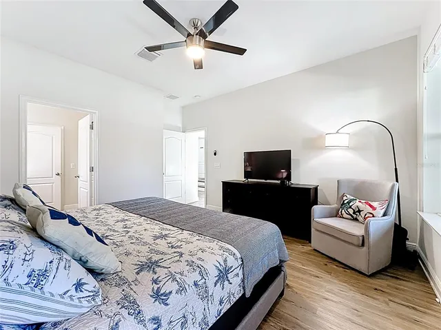 a bedroom with a bed wall painting and a chandelier