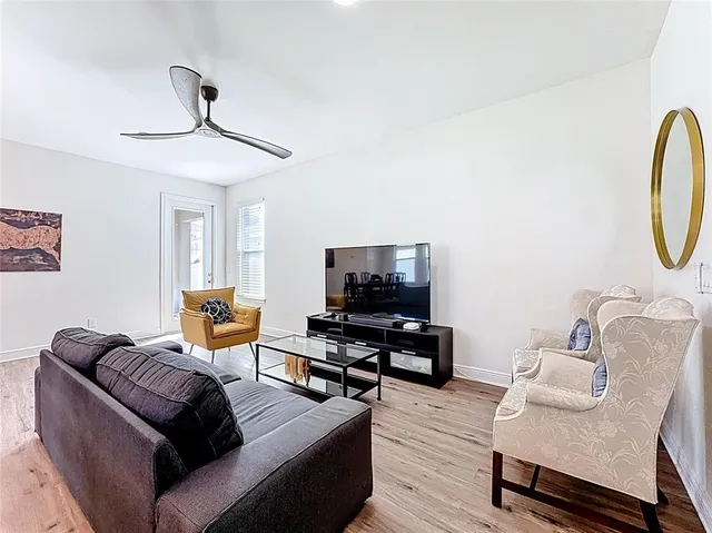 a living room with furniture a flat screen tv and a window