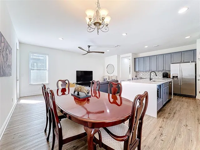 a view of a dining room with furniture a chandelier and wooden floor