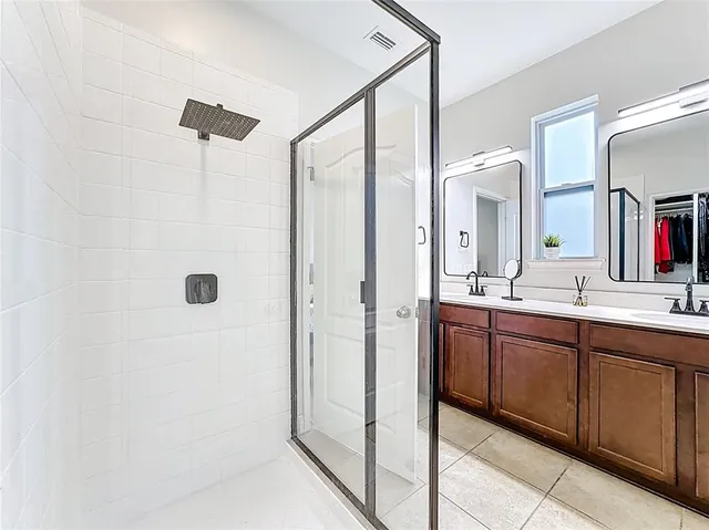 a bathroom with a double vanity sink a mirror and a shower