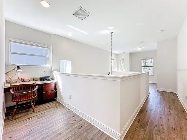 a kitchen with kitchen island a wooden floor and white appliances