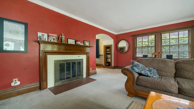 a living room with furniture a fireplace and a large window