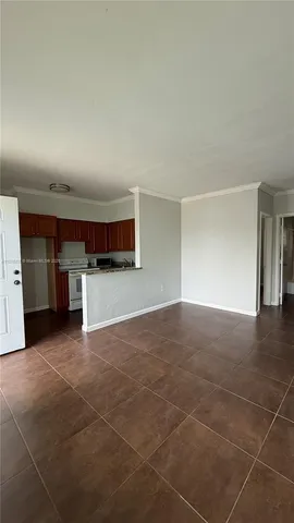 a view of a livingroom with kitchen and window