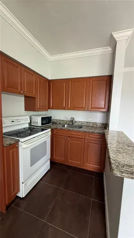a kitchen with granite countertop a stove a sink and dishwasher
