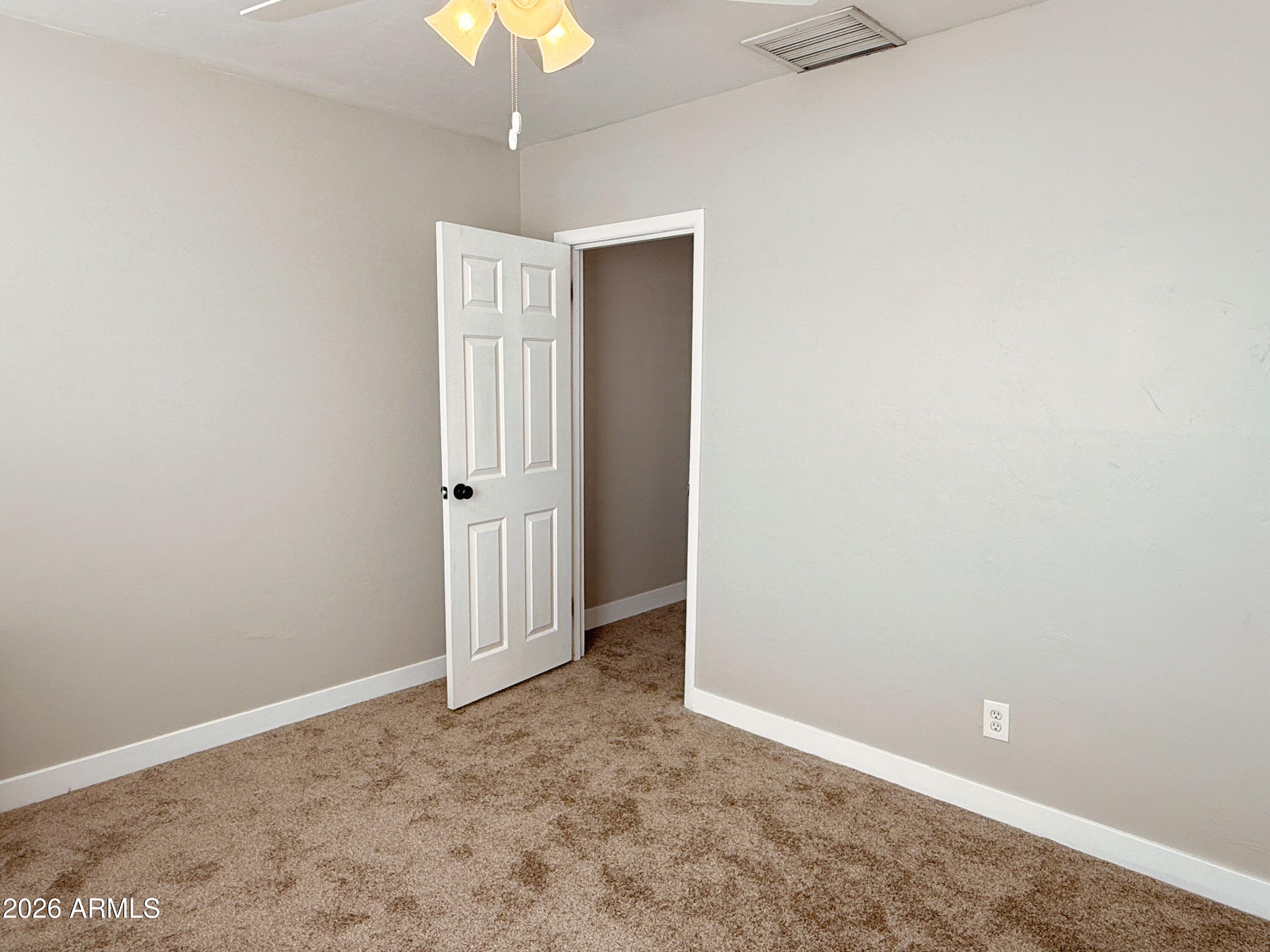 1220 West Romo Jones Street Tempe, AZ 85281 - Photo 14 of 26 an empty room with a chandelier fan