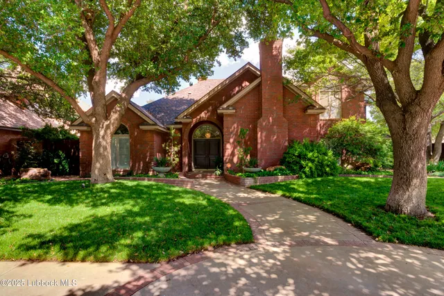 a view of a house with backyard and a tree