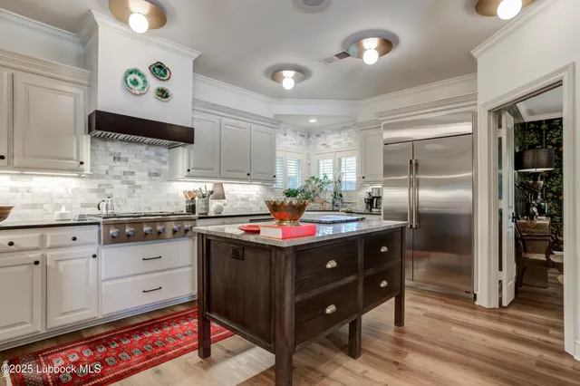 a kitchen with kitchen island granite countertop a stove and a sink