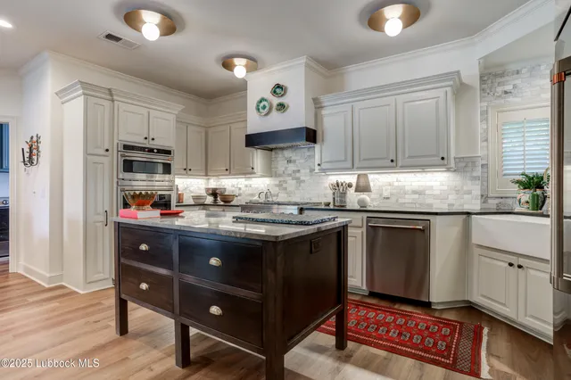 a kitchen with stainless steel appliances granite countertop a sink stove and cabinets