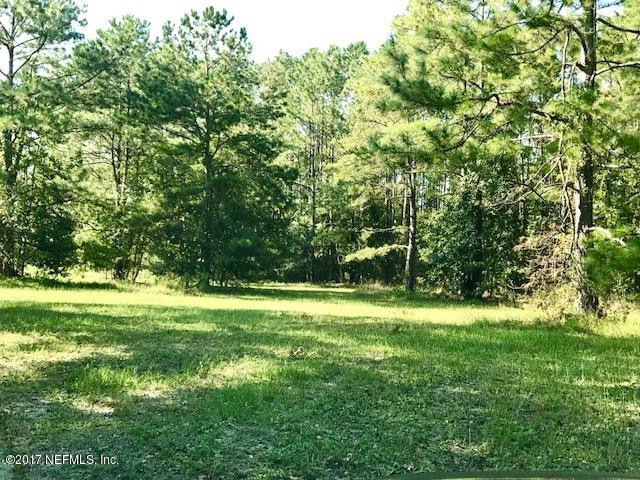 3098 Pacetti Road, Unit G St. Augustine, FL 32092 - Photo 4 of 17 a view of a grassy field with trees in the background