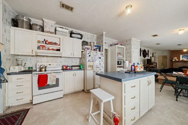 a kitchen with granite countertop a white cabinets and white appliances