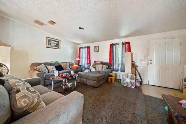 a living room with furniture and a gym machine