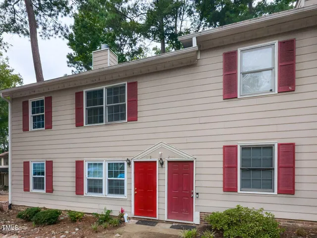 a front view of a house with a tree