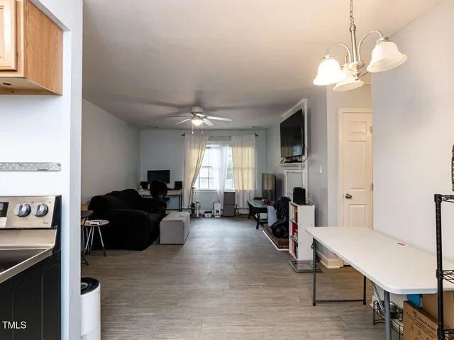a living room with furniture a fireplace and a chandelier