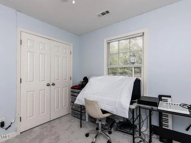 a view of a workspace with furniture and a window
