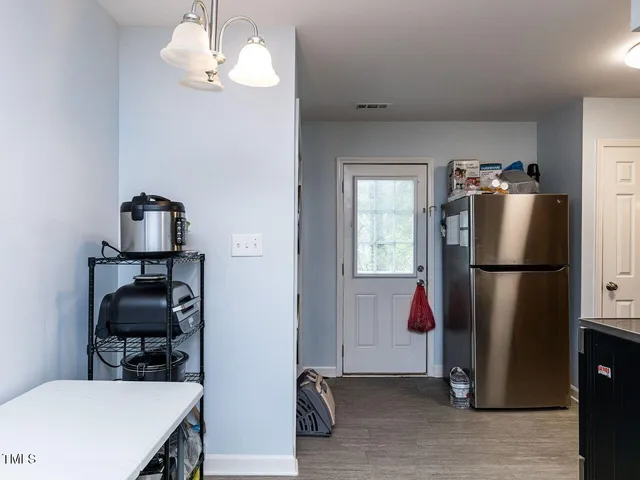 a kitchen with a refrigerator a stove and a dining table