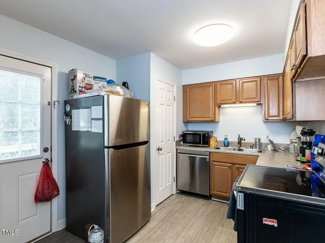 a kitchen with stainless steel appliances a refrigerator sink and cabinets