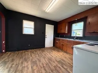 a open kitchen with kitchen island granite countertop sink and cabinets