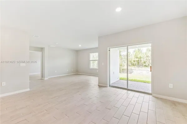 an empty room with floor to ceiling windows and chandelier