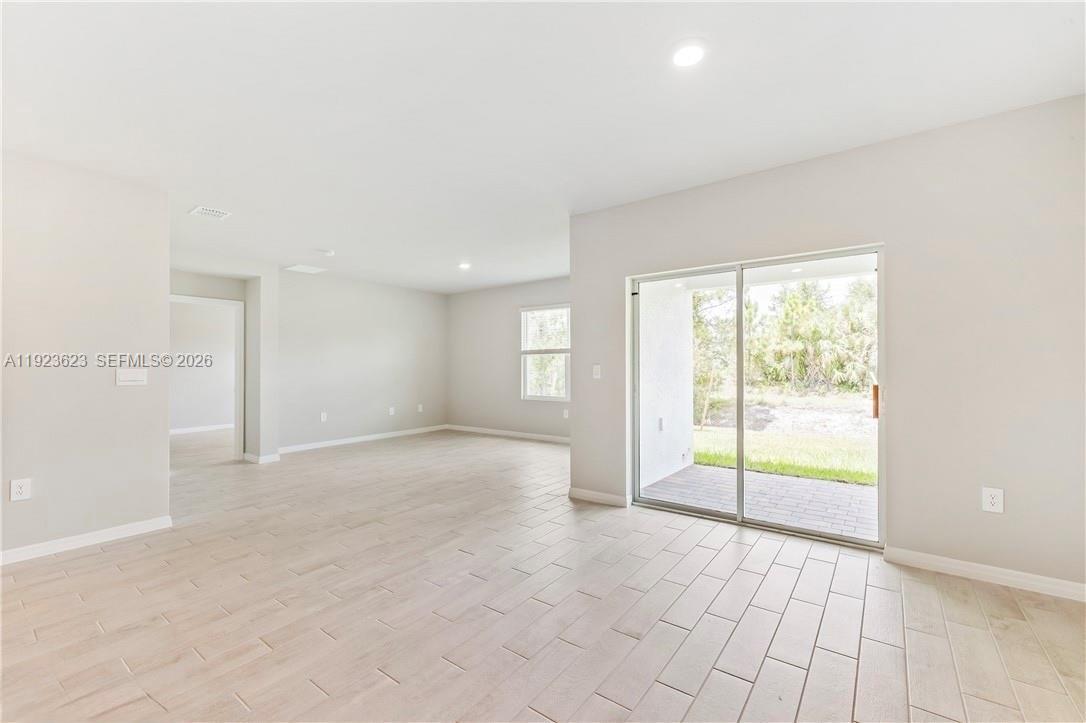 3021 North Lakewood Road LaBelle, FL 33935 - Photo 8 of 13 an empty room with floor to ceiling windows and chandelier