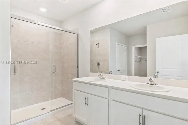 a bathroom with a shower sink vanity and mirror