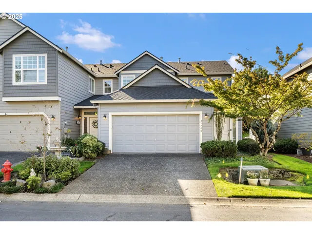 a view of a house with a small yard and potted plants