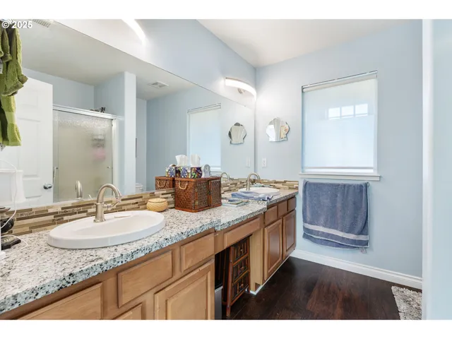 a bathroom with a granite countertop double vanity sink and a mirror