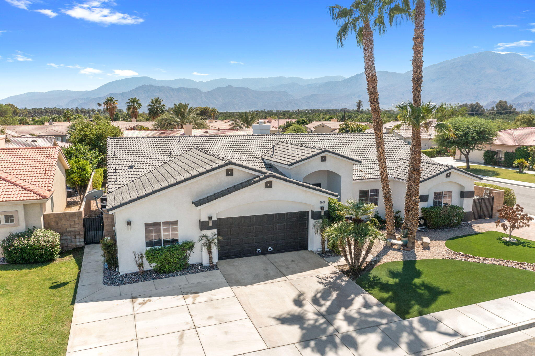 83035 Exeter Court Thermal, CA 92274 - Photo 3 of 38 a front view of a house with a yard and mountain view in back