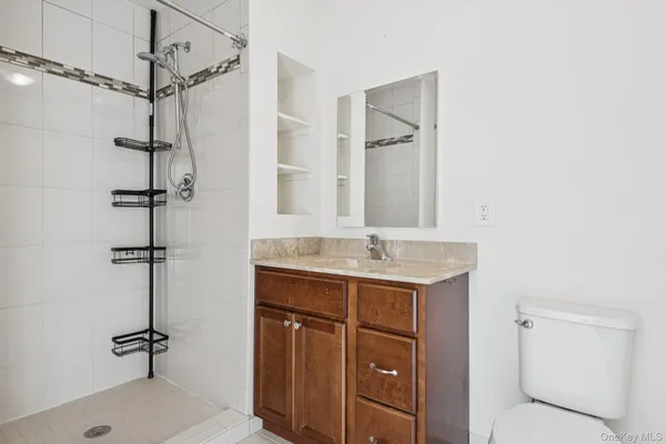 a bathroom with a granite countertop sink a mirror and shower