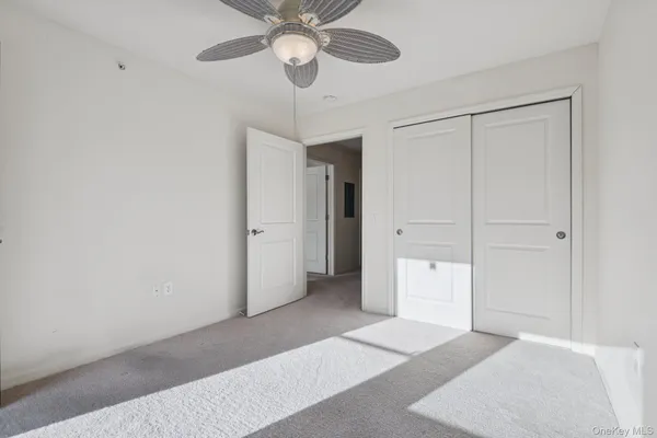 an empty room with a ceiling fan and a window