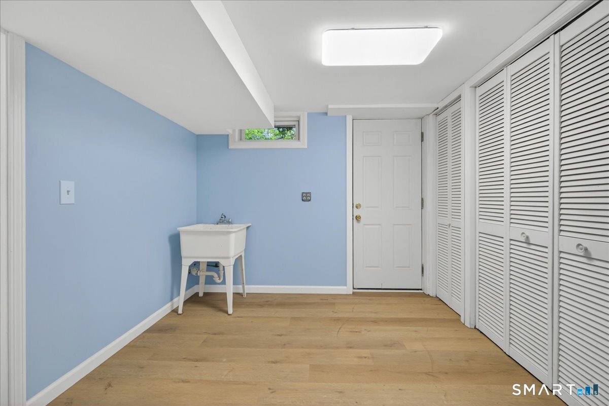 1006 King Road Cheshire, CT 06410 - Photo 27 of 40 The lower level has a utility sink, closets for storage and hatch doors to the backyard.