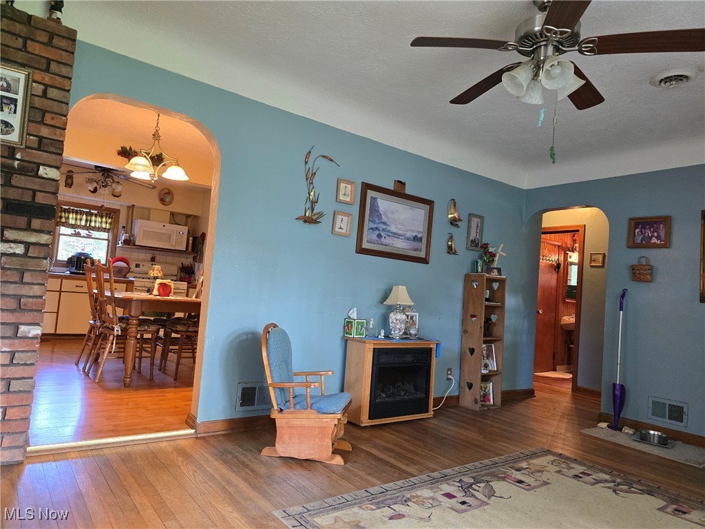 3181 Jaycox Road Avon, OH 44011 - Photo 39 of 48 Living room featuring arched walkways, hardwood / wood-style floors, a ceiling fan, and baseboards