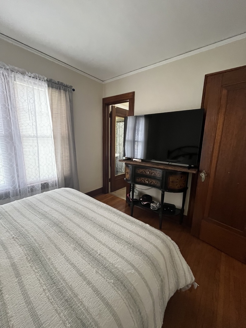 206 Oak Street, Unit 1R Elgin, IL 60123 - Photo 11 of 12 a bedroom with a bed and a flat screen tv
