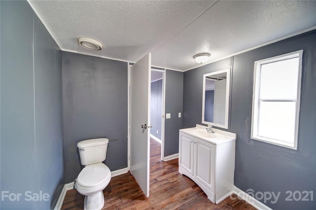 283 Ballard Spring Road, Unit 3276 Morven, NC 28119 - Photo 12 of 48 a bathroom with a toilet sink a mirror and a window