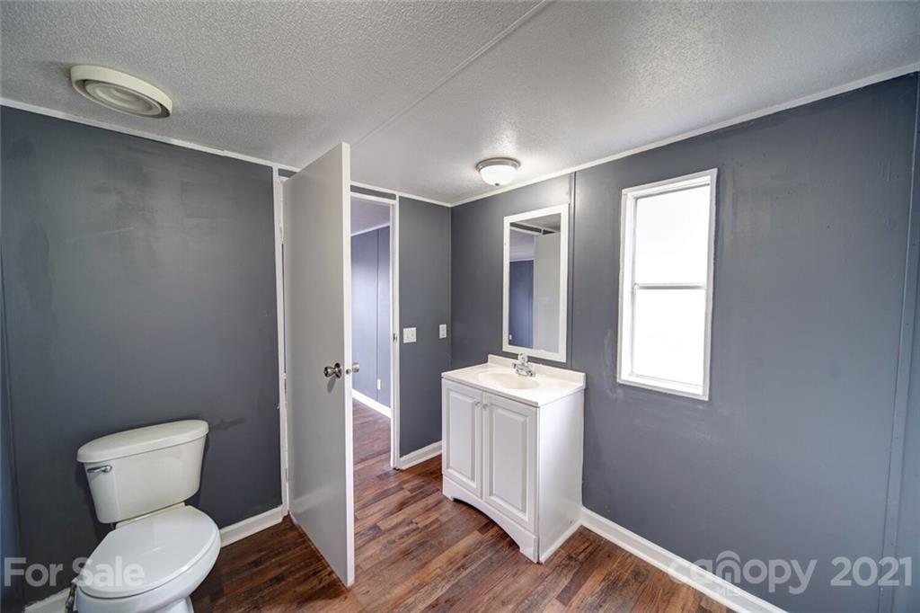 283 Ballard Spring Road, Unit 3276 Morven, NC 28119 - Photo 15 of 48 a bathroom with a toilet a sink and mirror
