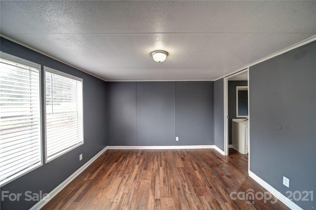 283 Ballard Spring Road, Unit 3276 Morven, NC 28119 - Photo 19 of 48 a view of an empty room with a window and wooden floor