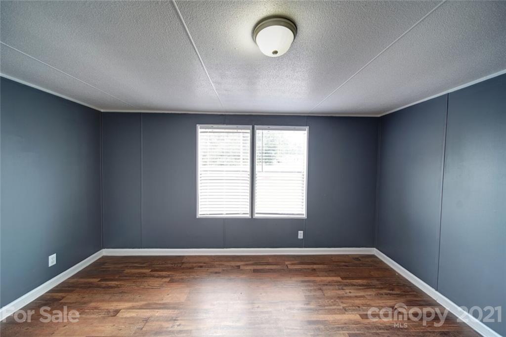 283 Ballard Spring Road, Unit 3276 Morven, NC 28119 - Photo 21 of 48 an empty room with wooden floor and windows